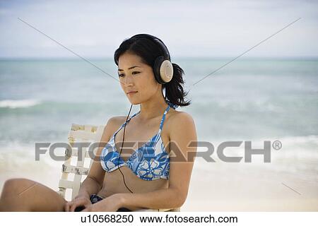 A woman listening to music at beach View Large Photo Image Stock Image - A woman listening to music at beach. Fotosearch