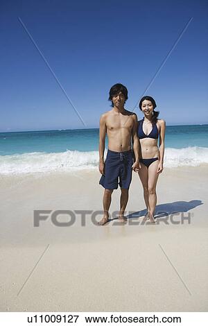 A young couple standing at beach View Large Photo Image Stock Photo - A young couple standing at beach. Fotosearch