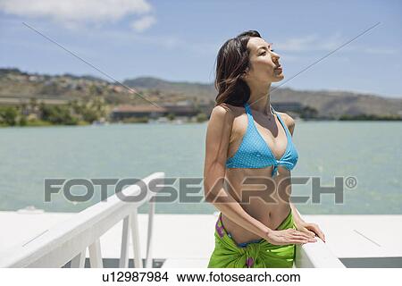 A young woman standing on pier View Large Photo Image Picture - A young woman standing on pier. Fotosearch