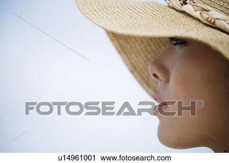 Stock Image - Close-up of young woman wearing hat. Fotosearch
