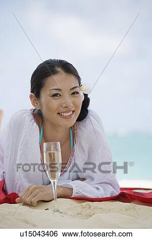Stock Photograph - Portrait of a young woman smiling at beach. Fotosearch