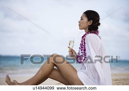 Profile of a young woman sitting at beach with wineglass View Large Photo Image Stock Photo - Profile of a young woman sitting at beach with wineglass. Fotosearch