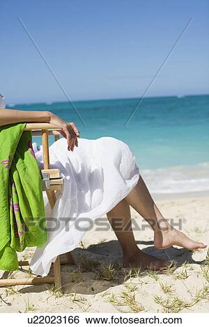 Low section of a woman sitting on chair View Large Photo Image Stock Photograph - Low section of a woman sitting on chair. Fotosearch