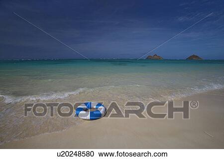 Stock Image - View of a life buoy on beach. Fotosearch