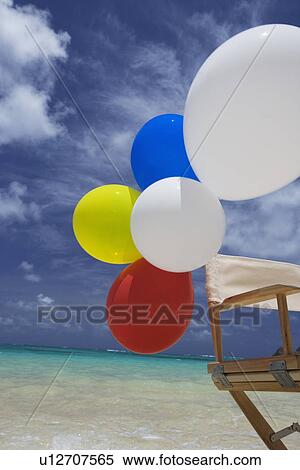 View of air balloons on wooden chair at beach View Large Photo Image Stock Photography - View of air balloons on wooden chair at beach. Fotosearch
