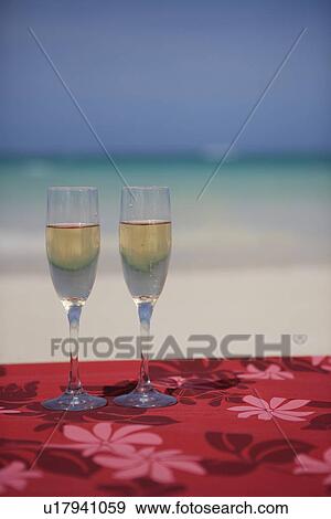 Wine glasses filled with drink in foreground View Large Photo Image Stock Photo - Wine glasses filled with drink in foreground. Fotosearch