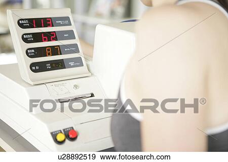 A woman looks over the readings of a digital indicator in the gym View Large Photo Image Stock Photo - A woman looks over the readings of a digital indicator in the gym. Fotosearch