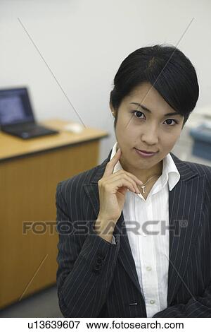A professional woman smiling at the camera in her office View Large Photo Image Stock Photo - A professional woman smiling at the camera in her office. Fotosearch