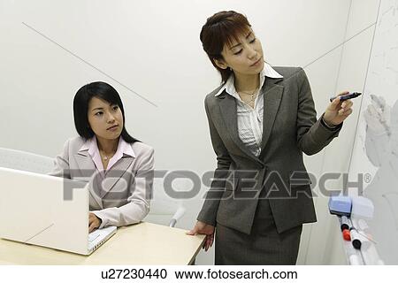 A woman explains some important points to her colleague View Large Photo Image Stock Image - A woman explains some important points to her colleague. Fotosearch