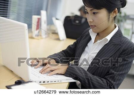 A woman working on the laptop in her office View Large Photo Image Stock Photo - A woman working on the laptop in her office. Fotosearch
