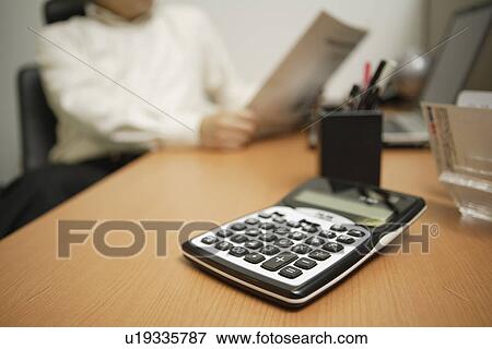 Stock Photo - Calculator on a desk, close-up. Fotosearch