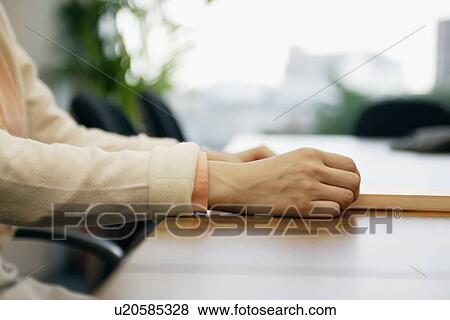 Hands of a woman seen holding a sheet View Large Photo Image Stock Photo - Hands of a woman seen holding a sheet. Fotosearch