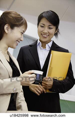 Stock Photo - Two professional women enjoying each others company. Fotosearch