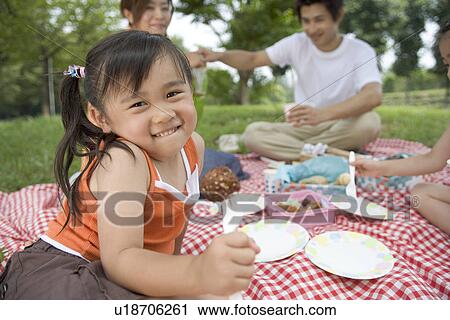 A girl having lunch by the trees with her family View Large Photo Image Stock Image - A girl having lunch by the trees with her family. Fotosearch
