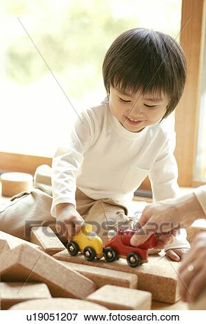 A small boy dashing his toy car with the one held by a person View Large Photo Image Stock Photo - A small boy dashing his toy car with the one held by a person. Fotosearch
