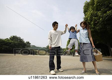 Stock Image - A young couple with their son in a park. Fotosearch