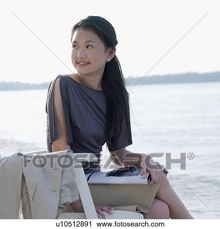 Businesswoman sitting on a chair at the beach View Large Photo Image Stock Image - Businesswoman sitting on a chair at the beach. Fotosearch