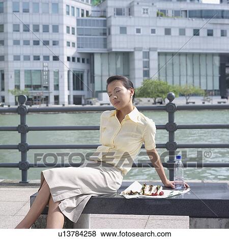 Stock Photo - Businesswoman sitting with her eyes closed. Fotosearch
