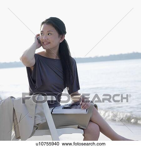 Businesswoman talking on a mobile phone at the beach View Large Photo Image Stock Image - Businesswoman talking on a mobile phone at the beach. Fotosearch