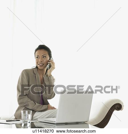 Businesswoman talking on a mobile phone smiling View Large Photo Image Stock Image - Businesswoman talking on a mobile phone smiling. Fotosearch