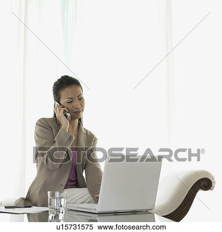 Stock Photography - Businesswoman talking on a mobile phone. Fotosearch