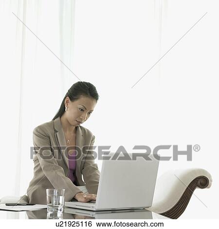 Stock Photograph - Businesswoman working on a laptop. Fotosearch
