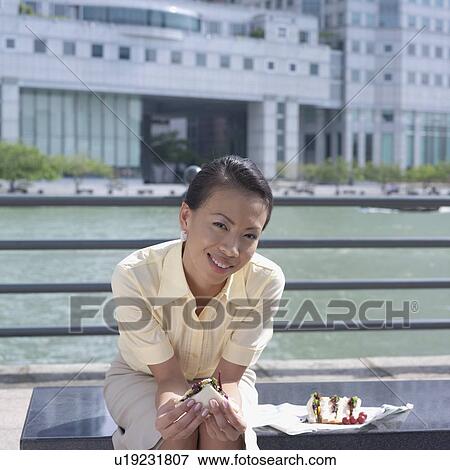 Portrait of a businesswoman holding a sandwich View Large Photo Image Stock Photo - Portrait of a businesswoman holding a sandwich. Fotosearch