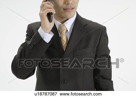 View of a professional talking on his mobile phone View Large Photo Image Stock Photo - View of a professional talking on his mobile phone. Fotosearch