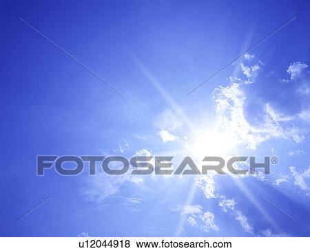 Stock Photo - View of blue sky and sun rays. Fotosearch