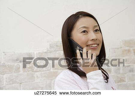A young woman using cellphone View Large Photo Image Stock Photography - A young woman using cellphone. Fotosearch