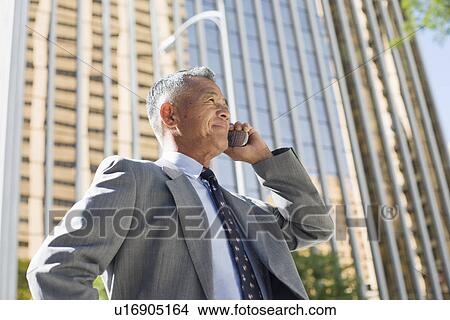 Businessman using mobile phone View Large Photo Image Picture - Businessman using mobile phone. Fotosearch