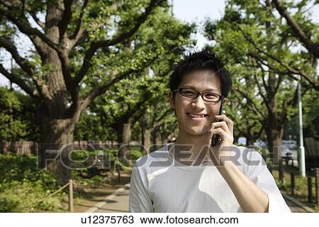 Portrait of a young man talking on mobile phone View Large Photo Image Stock Image - Portrait of a young man talking on mobile phone. Fotosearch