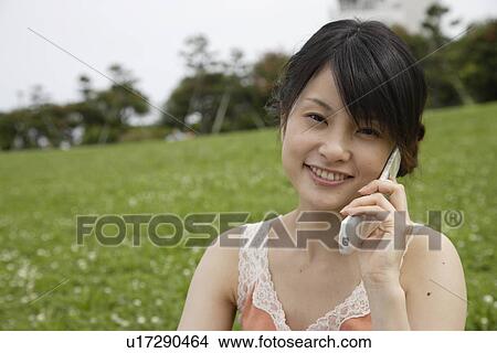 Picture - Portrait of a young woman talking on mobile phone. Fotosearch