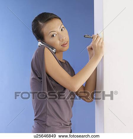 Side profile of a young woman talking on a mobile phone View Large Photo Image Stock Photo - Side profile of a young woman talking on a mobile phone. Fotosearch
