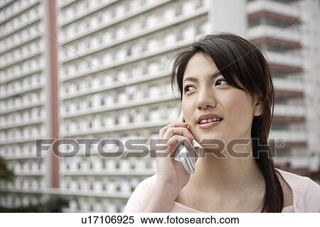 View of a young woman using mobile phone View Large Photo Image Stock Photography - View of a young woman using mobile phone. Fotosearch