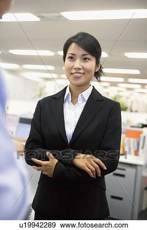 A formally dressed woman gives a smile at her colleague View Large Photo Image Stock Photo - A formally dressed woman gives a smile at her colleague. Fotosearch
