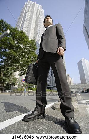 Low angle view of a businessman View Large Photo Image Stock Photography - Low angle view of a businessman. Fotosearch