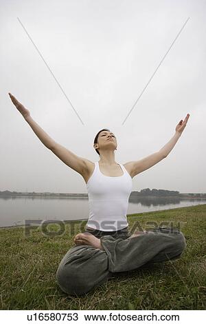 Front view of a young woman in lotus position View Large Photo Image Stock Image - Front view of a young woman in lotus position. Fotosearch