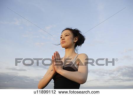 Low angle view of young woman performing yoga View Large Photo Image Stock Image - Low angle view of young woman performing yoga. Fotosearch