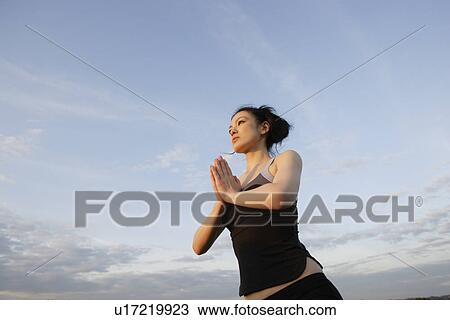 Low angle view of young woman performing yoga View Large Photo Image Stock Image - Low angle view of young woman performing yoga. Fotosearch