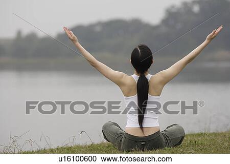 Rear view of a young woman in lotus position View Large Photo Image Stock Image - Rear view of a young woman in lotus position. Fotosearch