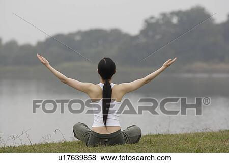 Rear view of a young woman in lotus position View Large Photo Image Stock Photo - Rear view of a young woman in lotus position. Fotosearch