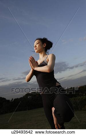 Stock Image - Side view of a young woman with tree position. Fotosearch