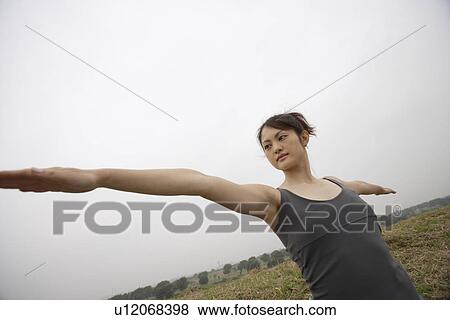 Stock Photo - Side view of a young woman with tree position. Fotosearch
