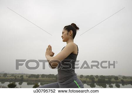 View of a young woman exercising beside the road View Large Photo Image Stock Image - View of a young woman exercising beside the road. Fotosearch