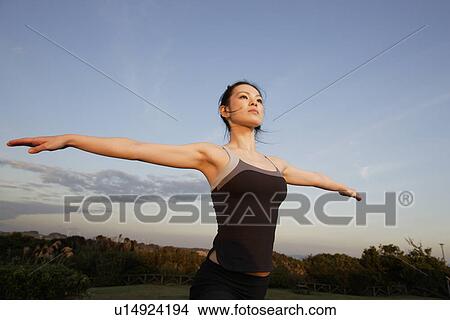 View of a young woman exercising outdoors View Large Photo Image Picture - View of a young woman exercising outdoors. Fotosearch