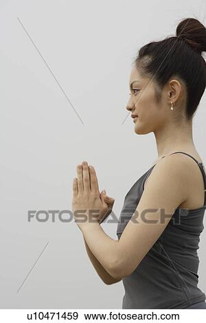 Stock Photo - View of a young woman with joined hands.. Fotosearch