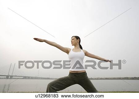 Stock Image - View of young woman exercising outdoors. Fotosearch