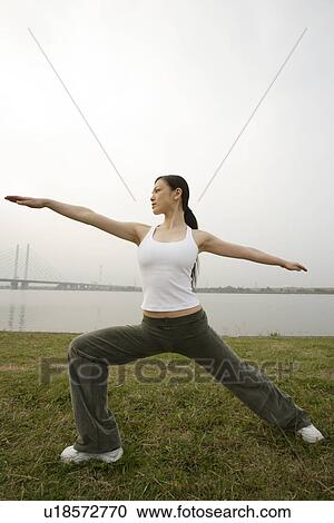 Stock Image - View of young woman exercising outdoors. Fotosearch