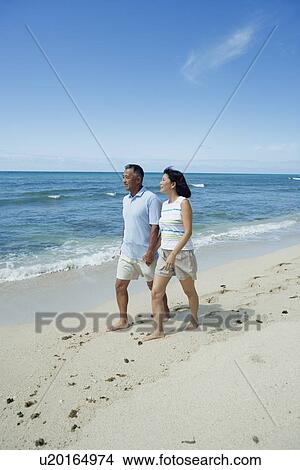 A couple walking at beach View Large Photo Image Picture - A couple walking at beach. Fotosearch
